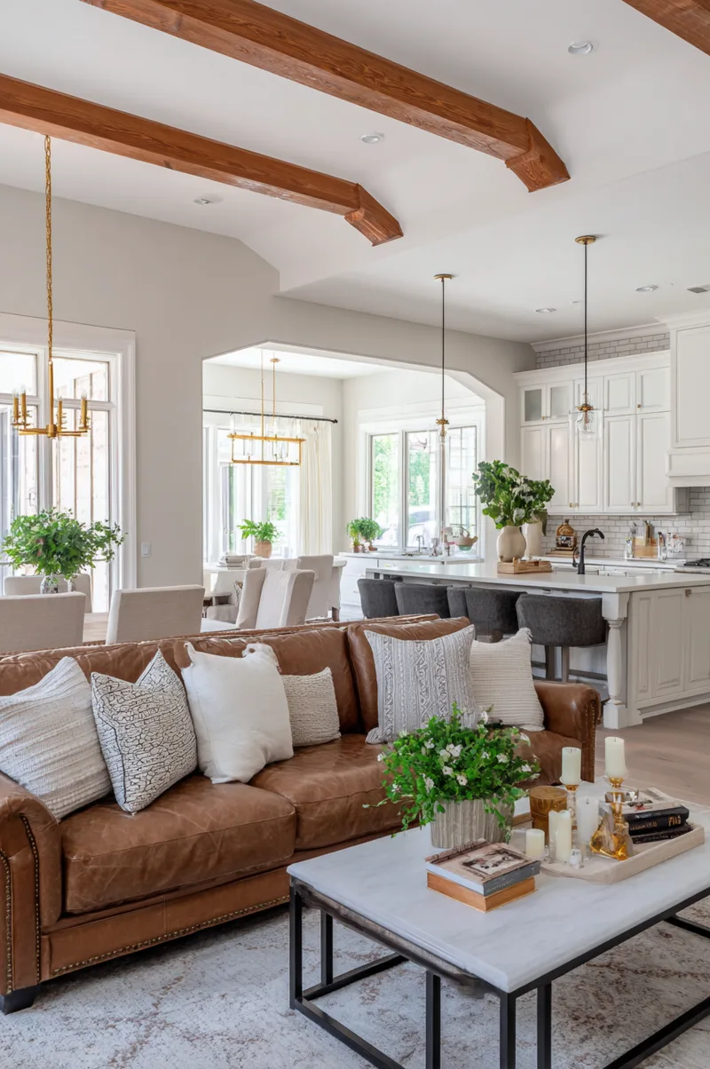 Large open kitchen and living room design with defined zones using a leather sofa and area rug to anchor the living space.